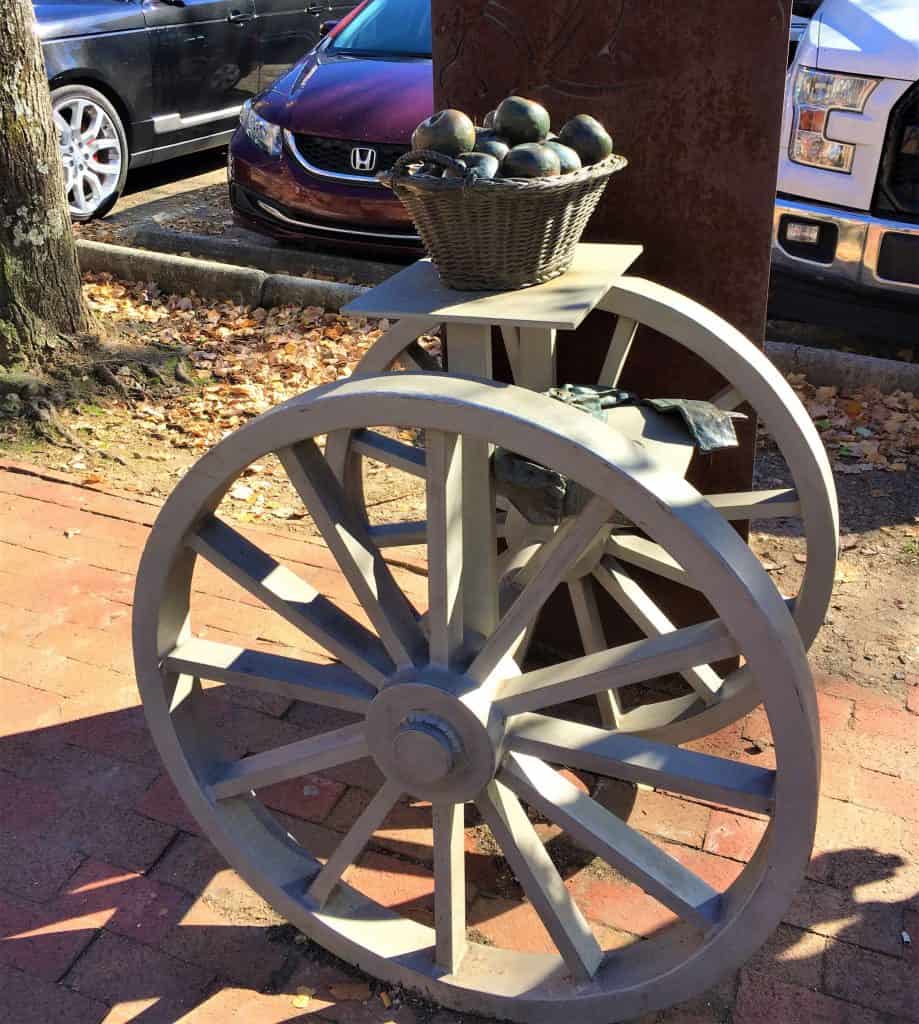 Two wheels with table in the middle by a parking lot are part of the Urban Trail.