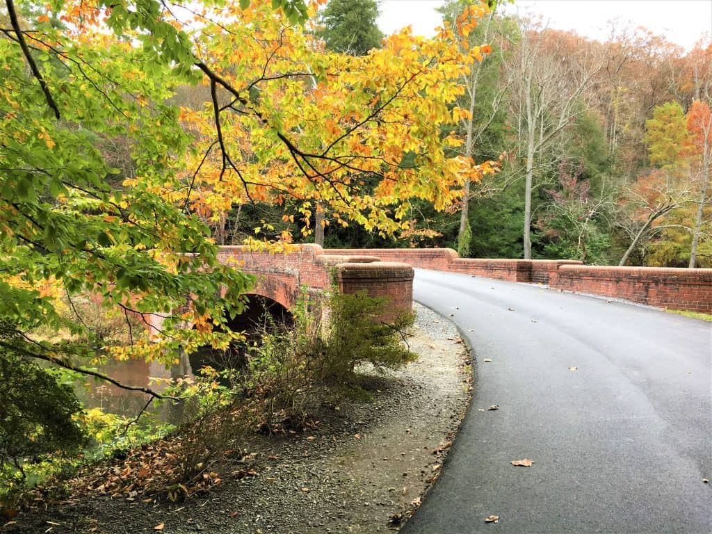 Road across bass pond lined with bricks which were laid by hand.