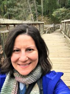 Photo of author standing on wooden bridge.