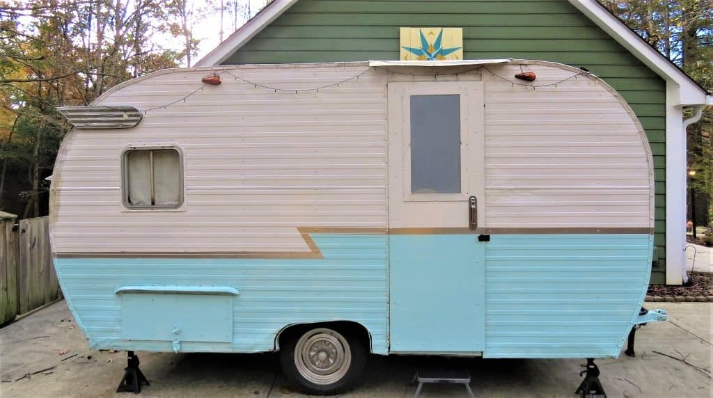 Exterior of the vintage trailer with light blue bottom and white top.