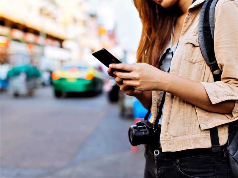 Female tourist using phone while traveling.