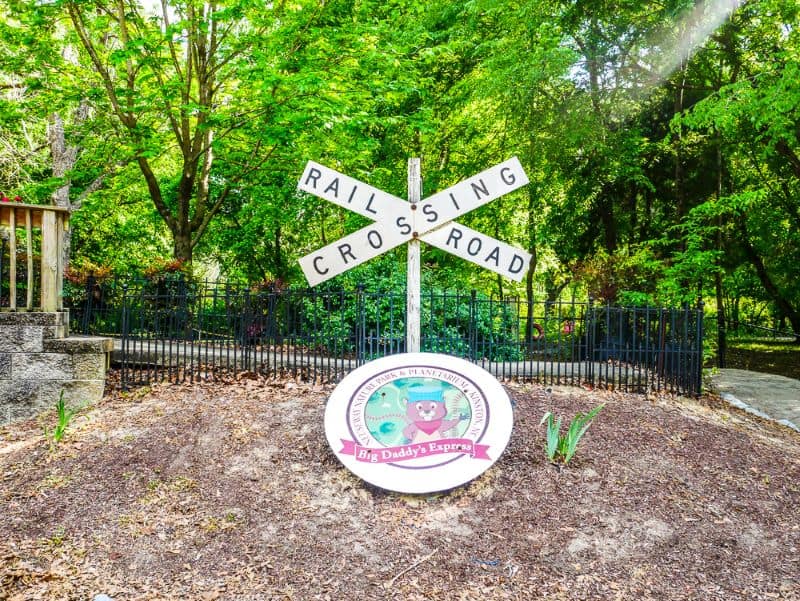 Railroad crossing sign near old train at Neuseway Nature Park