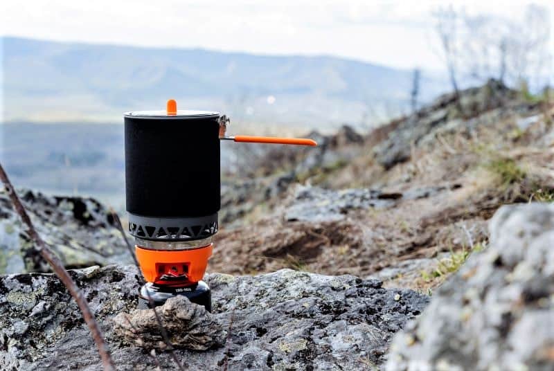 Backpacking pot sitting on a rocky mountain.