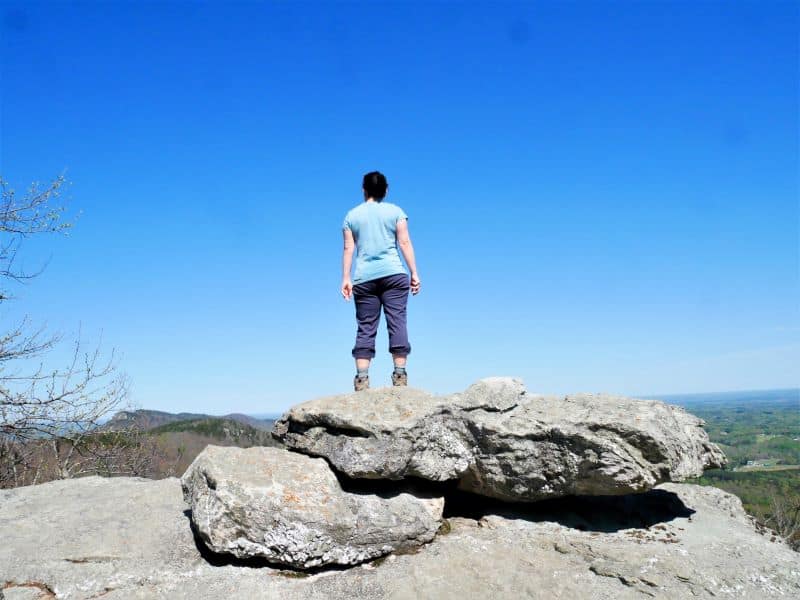 woman standing on the edge of House Rock overlook at Hanging Rock State Park in NC