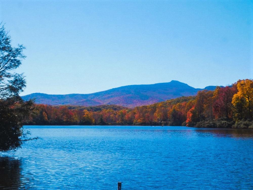 Julian Price Lake with ray of sun across the water and Table Rock in the back.