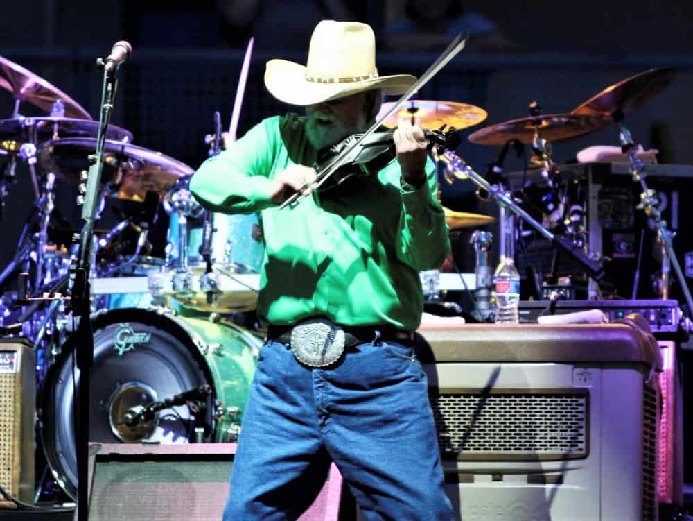 Charlie Daniels on stage playing his violin.