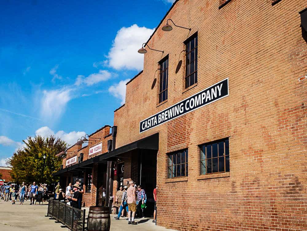 Front of Casitas Brewing Company building with line of people waiting.