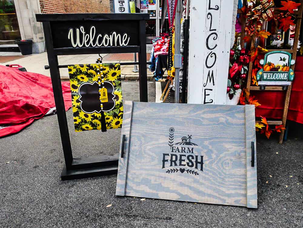 Homemade wooden signs saying Farm Fresh and Welcome from a local vendor.