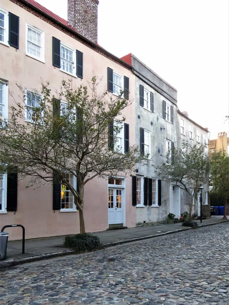 Charleston's French Quarter with cobblestone streets and buildings with faded exteriors. 