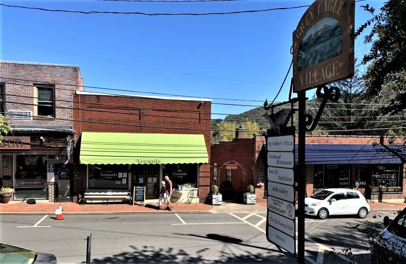 A block in downtown Black Mountain. There  are several single story buildings attached to each other and one separated. You can see the first one with a green awning and the name Veranda. 