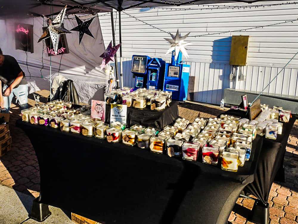 A local vendor selling soy candles in square, glass containers.