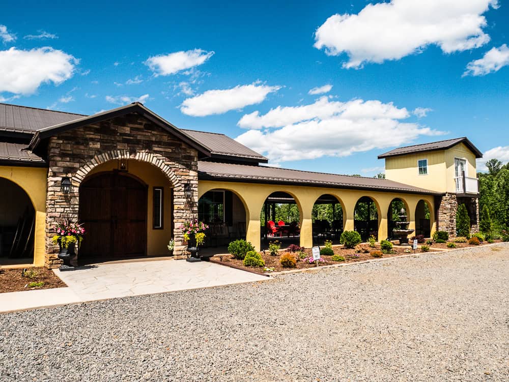 Yellow Tuscan inspired building with stone entrance by the door.